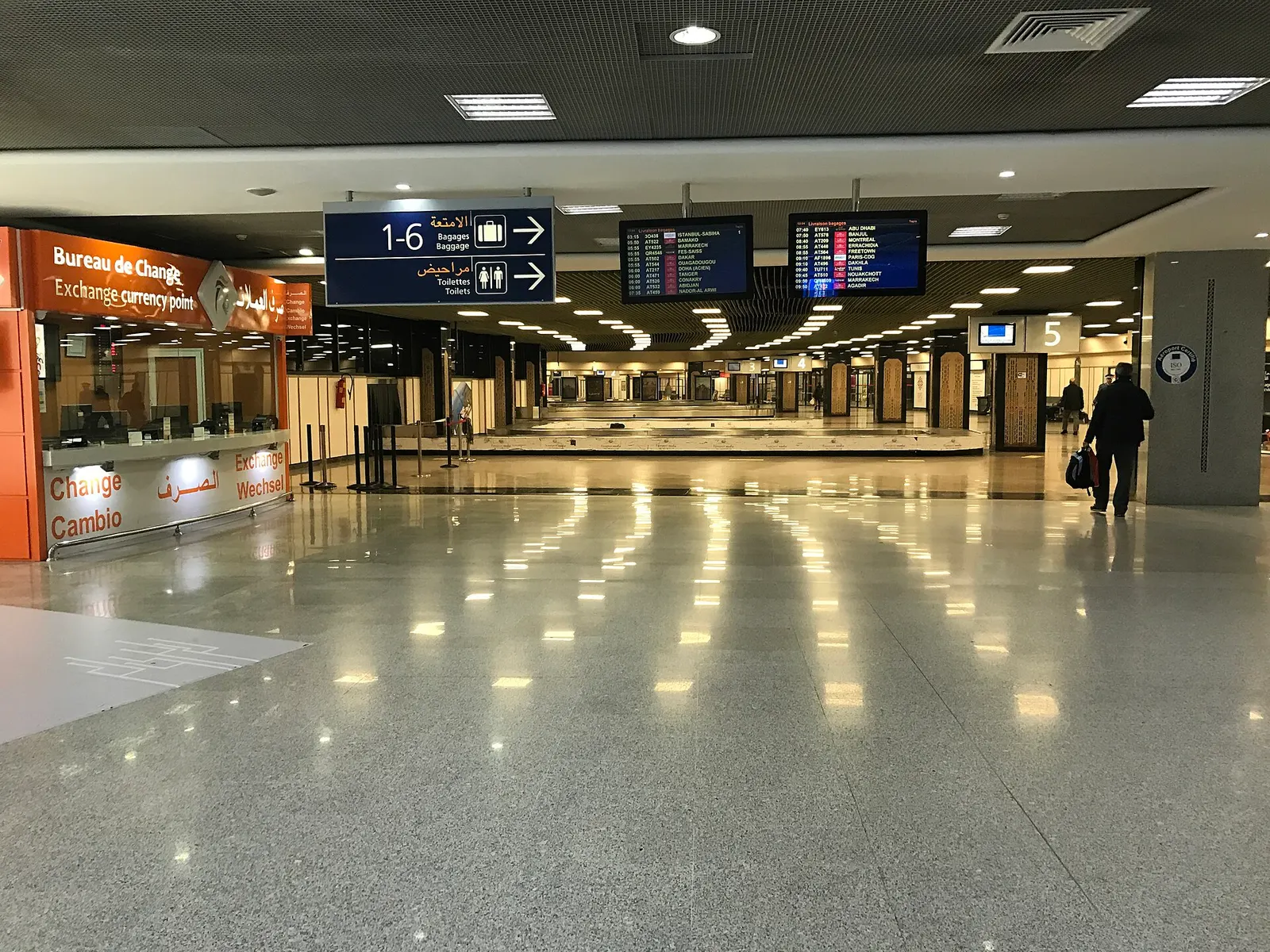 Salle de livraison des bagages de l'aéroport de Casablanca avec bureau de change et écrans