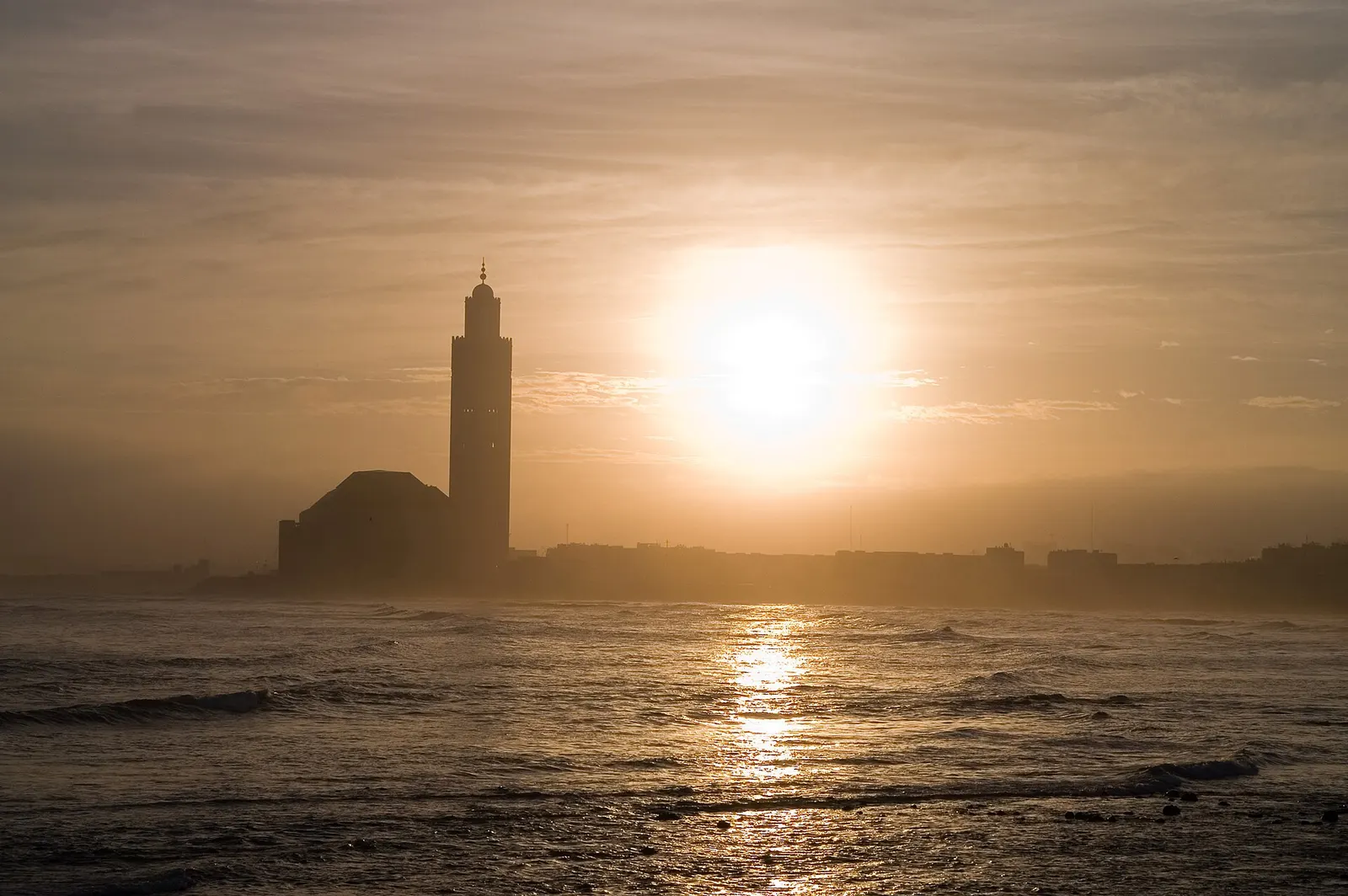 Minaret de la mosquée Hassan II se découpant sur l'océan Atlantique au soleil levant