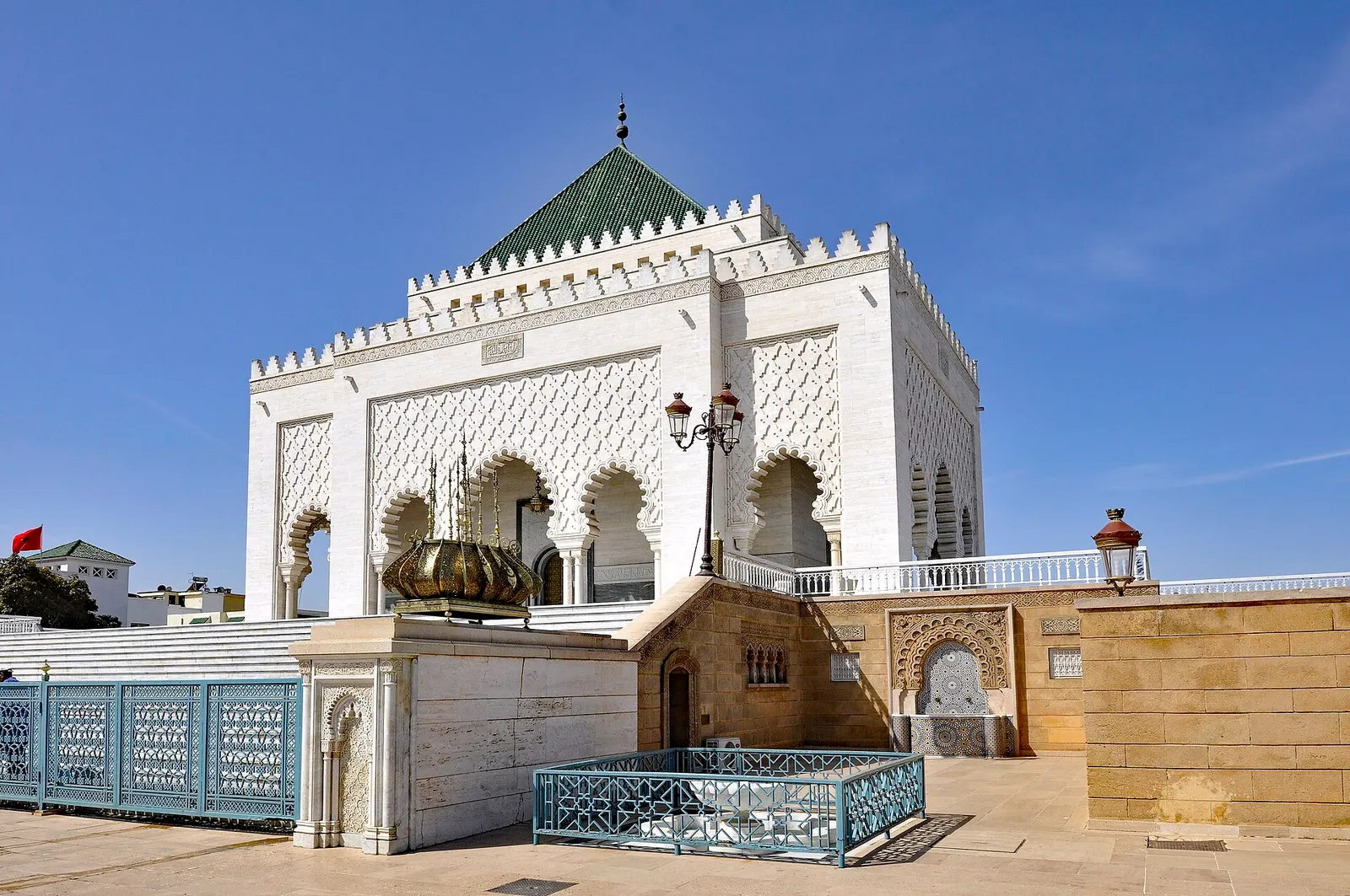Mohammed V Mausoleum in Rabat, carved white facade and green tiled roof under a blue sky
